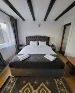 布加勒斯特Adac Boutique Hotel的一间卧室配有一张大床和两条毛巾