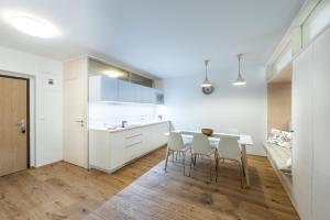 布拉迪斯拉发城堡墙公寓的厨房配有白色橱柜和桌椅