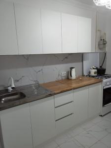 奎兹洛达Трешка на Автовокзале的厨房配有白色橱柜、水槽和炉灶。