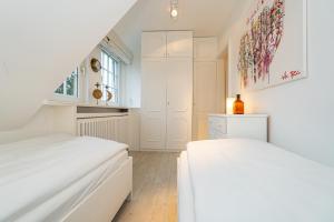 曼克玛肖Traumblick App 4的一间白色卧室,配有两张床和窗户