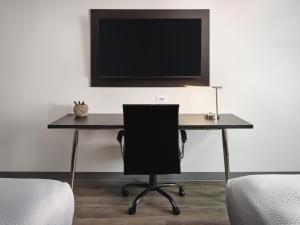 奥本stayAPT Suites Auburn的一张桌子、椅子和墙上的电视