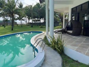 长滩岛Luxury Villa: Private Pool & Beach Retreat的一座带秋千的房子旁的游泳池
