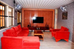 洛美BAMBOO LODGE - la Criquet 'Event'的客厅配有红色家具和平面电视