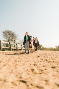 费马恩Büdlfarm - Der Familien-Erlebnishof in Strandnähe的一群人把狗放在泥土上