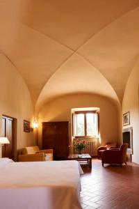 科尔托纳博尔戈伊尔美罗奈酒店的一间卧室设有一张床和一间客厅。