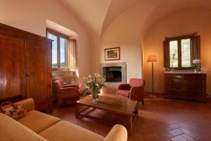 科尔托纳博尔戈伊尔美罗奈酒店的客厅配有沙发和桌子