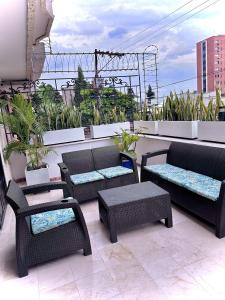 卡利The View Hostel & Lounge的阳台的天井配有桌椅
