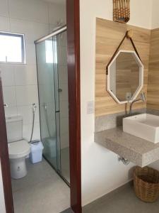 圣米格尔-杜戈斯托苏Flor de Cacto Beach Home的一间带卫生间、水槽和镜子的浴室