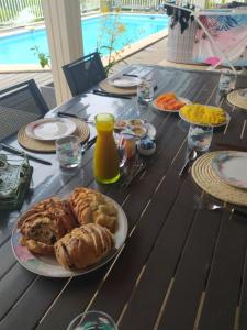 圣若瑟Les oliviers sous le cocotier的一张桌子上放着一盘早餐食品