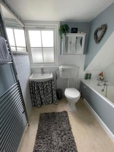 威尔汉姆Cottages at Woodlands, Dormer的浴室配有盥洗池、卫生间和浴缸。