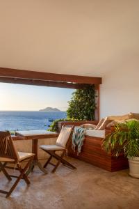 布希奥斯卡萨斯布兰卡斯精品酒店加Spa的阳台配有椅子和床,享有海景。
