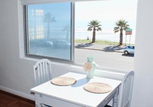 开普敦Villa Capri的一张带两把椅子的白色桌子和一个享有海滩美景的窗户