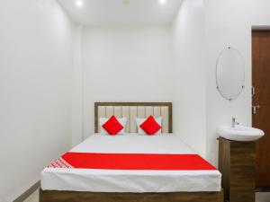 那格浦尔OYO Flagship Hotel Rahul Service Appartment 2的一间卧室配有一张带红色枕头和水槽的床