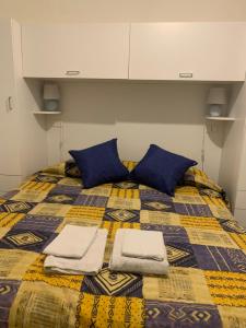 切塔拉La casa a mare的一张带蓝色枕头的床和毛巾