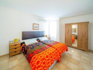 Cala AnguilaHoliday Home Bonita by Interhome的一间卧室配有一张带橙色棉被的床