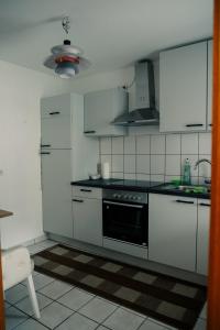 萨尔斯塔特Ostertor 2的厨房配有白色橱柜和炉灶烤箱。