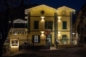 萨索马可尼Hotel Ca' di Gali的夜晚装饰着圣诞灯的房子