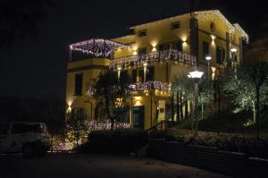 萨索马可尼Hotel Ca' di Gali的一座晚上用圣诞灯装饰的建筑