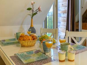 巴登Apartment Le Château de Kergonano-10 by Interhome的一张桌子,上面放着一篮面包和橙汁