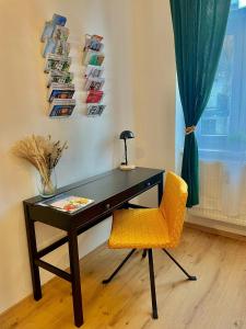 格拉茨JS Design Apartment的一张桌子,旁边是一张靠窗的黄色椅子