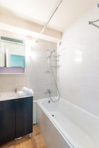 蒂涅Studio Home Club - Lavachet-12 by Interhome的白色的浴室设有浴缸和水槽。