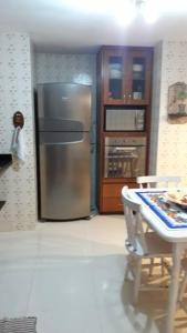 布希奥斯Casa completa + área gourmet的厨房配有不锈钢冰箱和桌子