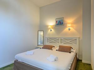 巴登Apartment Le Château de Kergonano-12 by Interhome的卧室配有一张带两个枕头的大白色床
