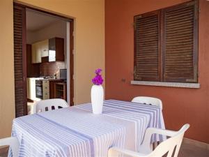 特里尼达古图Apartment Tanca Torre 60P by Interhome的一张桌子,上面有花瓶,上面有紫色花