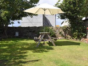 Mawbray2 bed property in Mawbray Cumbria SZ214的院子里带雨伞的野餐桌