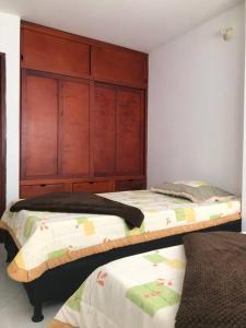 巴兰卡韦梅哈Acogedor apartamento en Barrancabermeja的一间卧室设有两张床和木制床头板