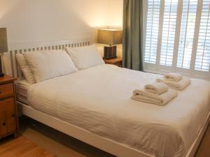霍普湾Cindy's Retreat的卧室配有白色床和毛巾