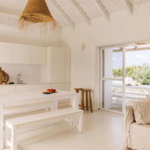 孔波尔塔Casas de Arroz的白色的厨房配有长凳和桌子