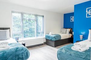 南安普敦Executive 8beds 3bath Contractors Welcome Parking的一间卧室设有两张床和蓝色的墙壁