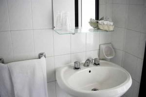 里米尼Hotel Laura Beach的白色的浴室设有水槽和镜子