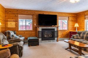 卡尔卡斯卡Lake Manistee Lodge Ski & Snowmobile Hideout的客厅设有壁炉和平面电视。