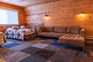 卡尔卡斯卡Lake Manistee Lodge Ski & Snowmobile Hideout的客厅配有沙发和1张床