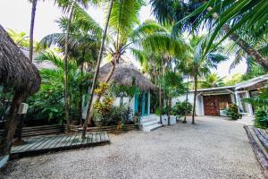 图卢姆Hotel Cormoran Tulum & Cenote的前面有棕榈树的房子