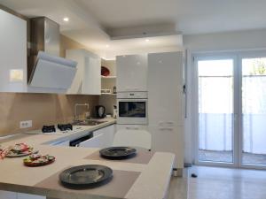 加尔达湖滨Casa Akira的厨房配有白色橱柜和台面