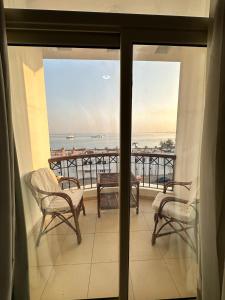 赫尔格达赫尔格达艾拉利亚酒店的阳台配有椅子,享有海景。