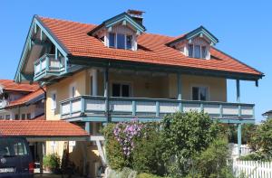 基姆湖畔贝尔瑙Ferienwohnung Bernau的带阳台的橙色屋顶房屋