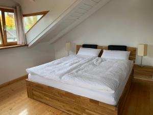 基姆湖畔贝尔瑙Ferienwohnung Bernau的一间卧室配有一张带白色床单的大床