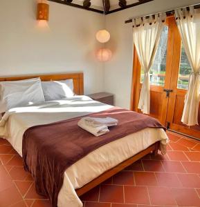 莱瓦镇VILLA CHARLOTTE 2 en colombia的一间卧室配有一张床,上面有两条毛巾