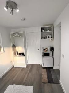 爱丁堡En-suite Room with Independent Entrance.的白色的厨房配有白色炉灶 顶部烤箱