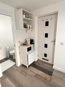 爱丁堡En-suite Room with Independent Entrance.的一间带炉灶和门的白色厨房