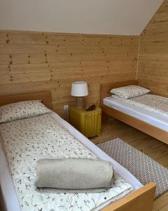 Seoski turizam Žigale的一间卧室设有两张床和一张桌子上的台灯。
