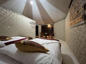 DisahLuxury tent camp的一间卧室配有两张床和一张桌子。
