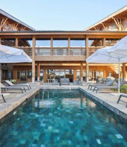 拉兹洛格Spacious penthouse chalet apartment in Pirin Golf and Country Club的一个带椅子和遮阳伞的游泳池