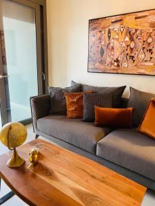 雅典NEW 2BDR apartment with SHARED ROOFTOP POOL的带沙发和木桌的客厅