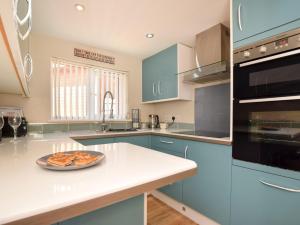 Scalby2 bed property in Howden 86817的厨房配有蓝色橱柜和柜台上的一盘食物