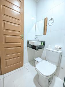 马拉戈日Pousada do Alemão的白色的浴室设有卫生间和水槽。